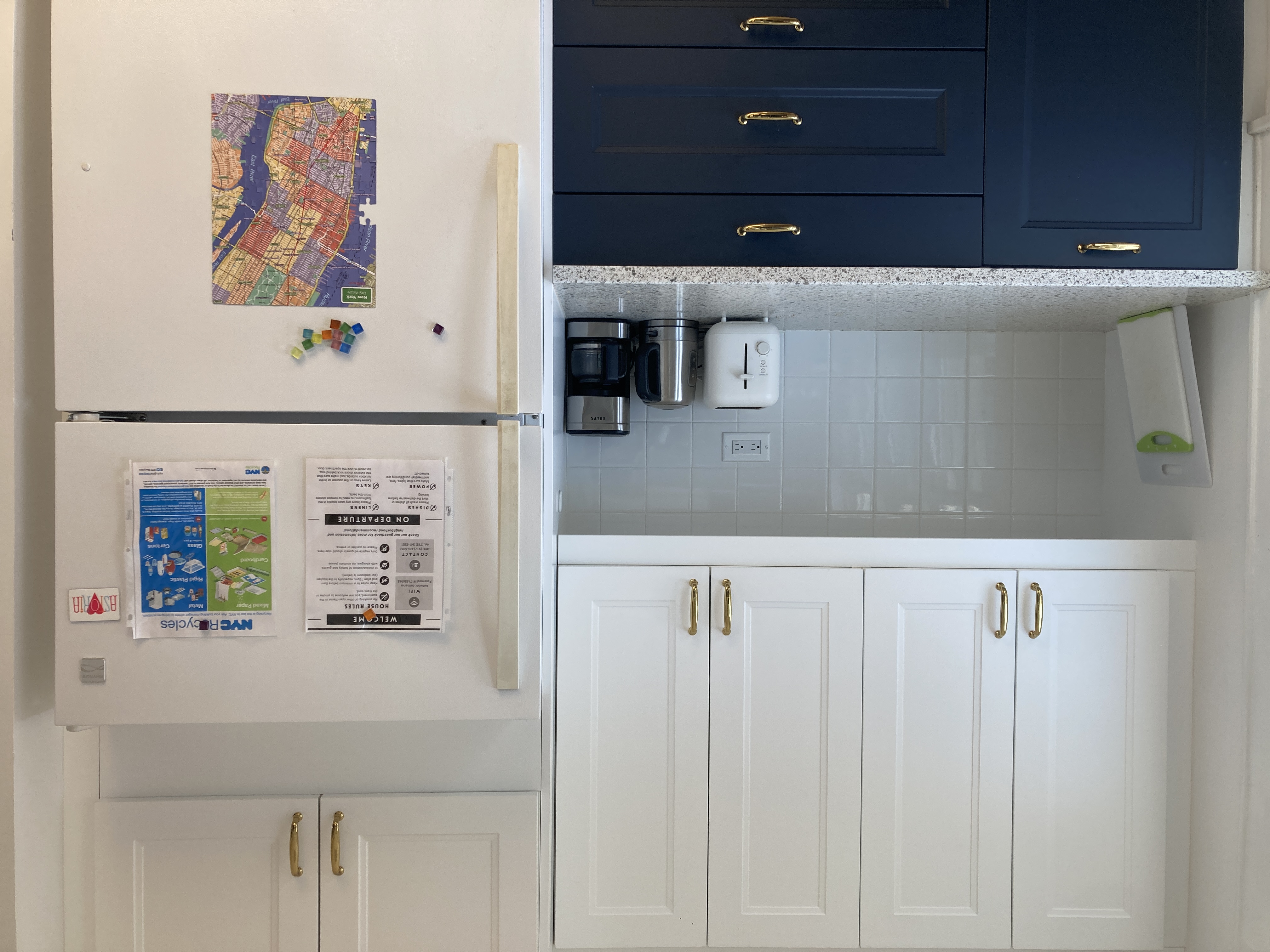 Kitchen with navy cabinets and gold hardware